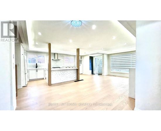 A spacious room with a white ceiling and wooden flooring.