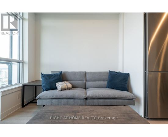A grey couch with a striped throw blanket on it.
