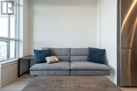 A grey couch with a striped throw blanket on it.