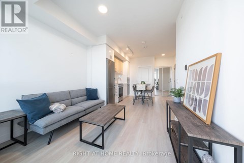 A living room with a grey couch and a wooden table.