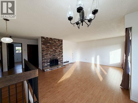 A large open room with a fireplace and a chandelier.