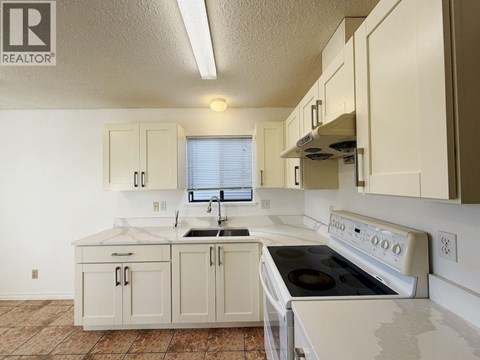 A kitchen with white appliances and cabinets.