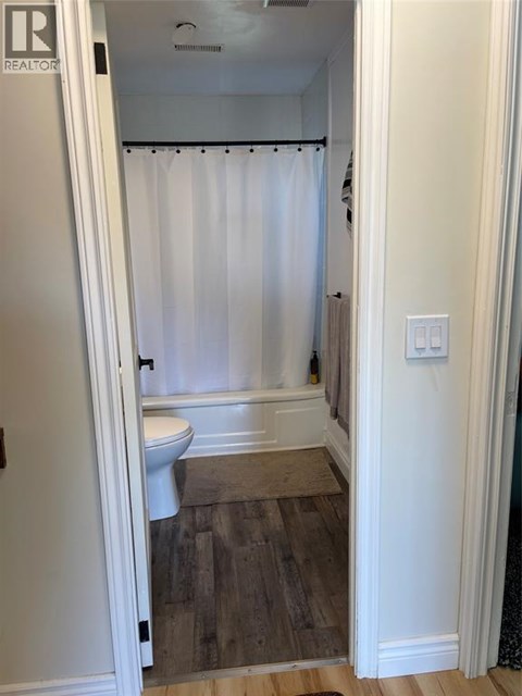 A white bathroom with a toilet and a bathtub.