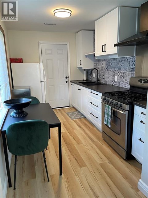 A kitchen with a black counter top and white cabinets.