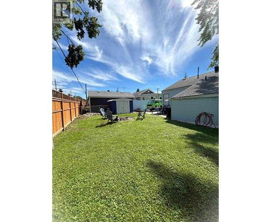 A backyard with a lawn and a shed.