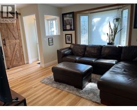 A living room with a brown leather couch and ottoman.
