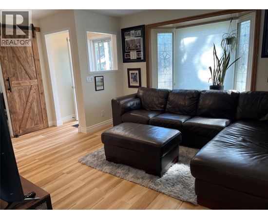 A living room with a brown leather couch and ottoman.