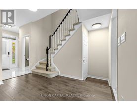 A staircase with a black railing and wooden steps leads up to a white door.