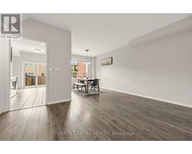 A spacious room with wooden flooring and white walls, furnished with a dining table and chairs.