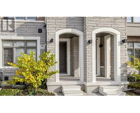A house with a grey facade and a white door.