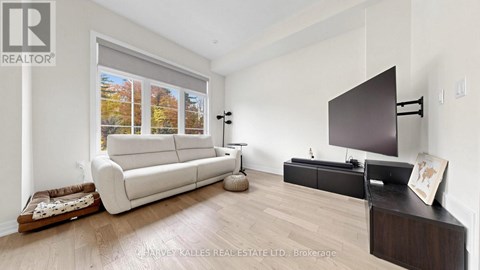A living room with a white couch and a flat screen TV.