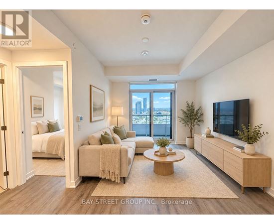 A well-lit, spacious living room with a television, couches, and a coffee table.