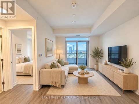 A well-lit, spacious living room with a television, couches, and a coffee table.