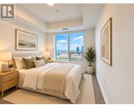 A bedroom with a large bed and a view of the city through the window.