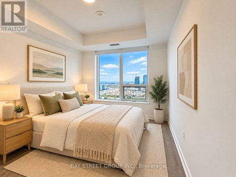 A bedroom with a large bed and a view of the city through the window.