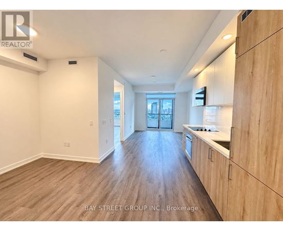 A spacious kitchen with wooden cabinets and a countertop.