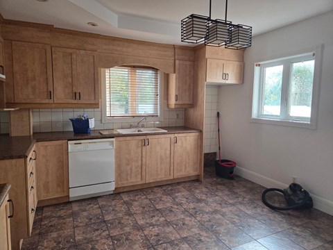 A kitchen with wooden cabinets and a tiled floor.