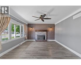 A spacious room with a fireplace and a ceiling fan.