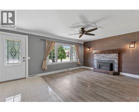 A living room with a fireplace and a ceiling fan.