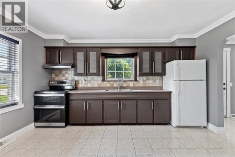 A kitchen with brown cabinets and a white refrigerator.