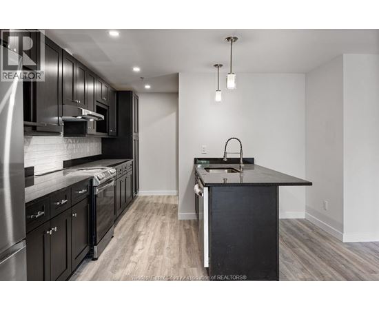 A modern kitchen with dark wood cabinets and a center island.