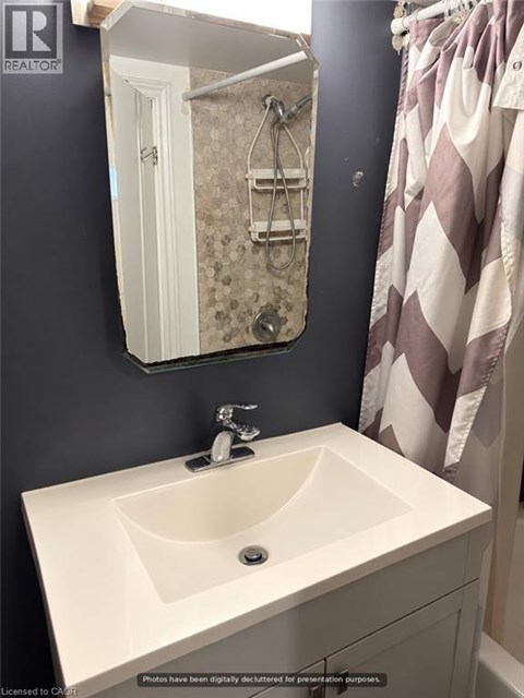 A white sink in a bathroom with a mirror above it.
