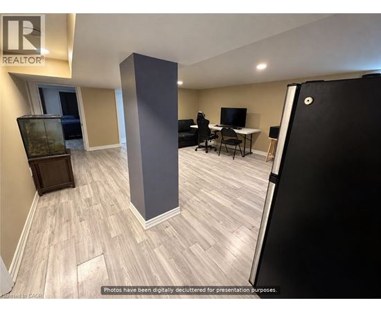 A room with a desk, chairs, and a television.