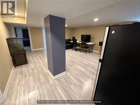 A room with a desk, chairs, and a television.