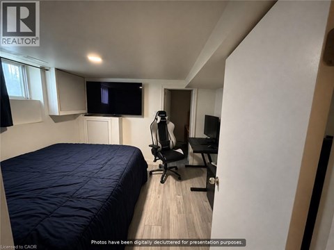 A bedroom with a bed, chair, and television.