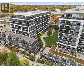 A bird's eye view of a residential area with apartment buildings and a green space in the middle.