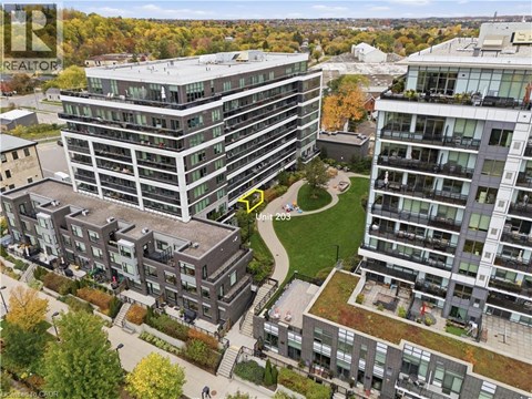 A bird's eye view of a residential area with apartment buildings and a green space in the middle.