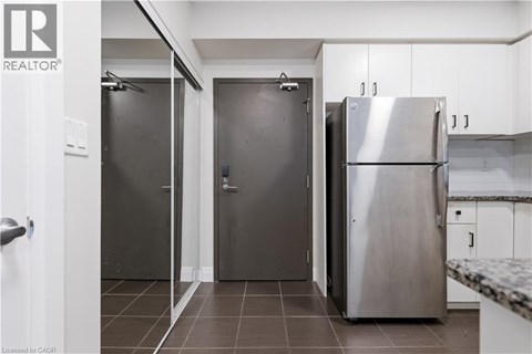 A kitchen with a refrigerator, two doors, and a counter.