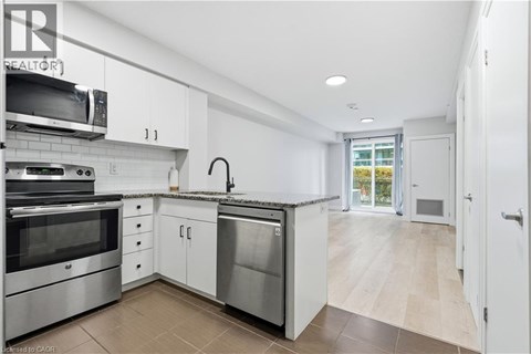 A modern kitchen with stainless steel appliances and white cabinets.