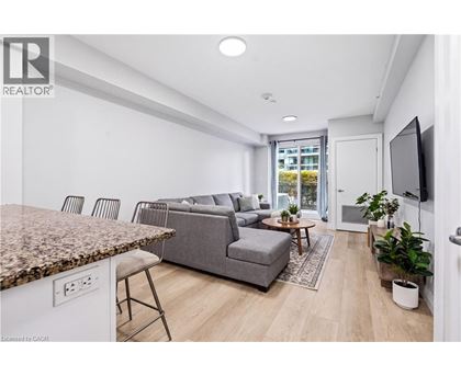 A living room with a grey couch and a brown granite counter.