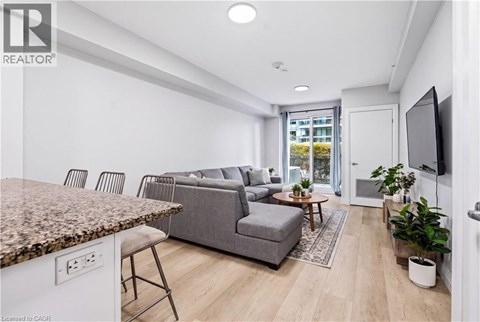 A living room with a grey couch and a brown granite counter.