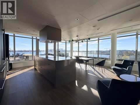 A spacious room with a view of the cityscape through large windows.