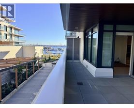 A balcony with a view of the water and buildings.