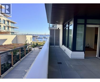 A balcony with a view of the water and buildings.