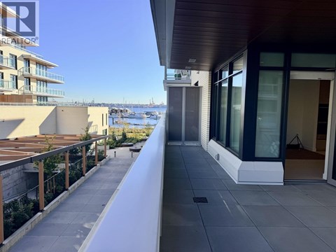 A balcony with a view of the water and buildings.