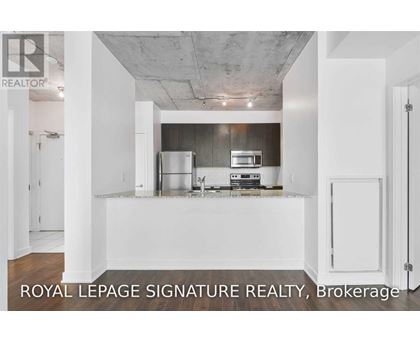 A kitchen with white cabinets and a stainless steel refrigerator.
