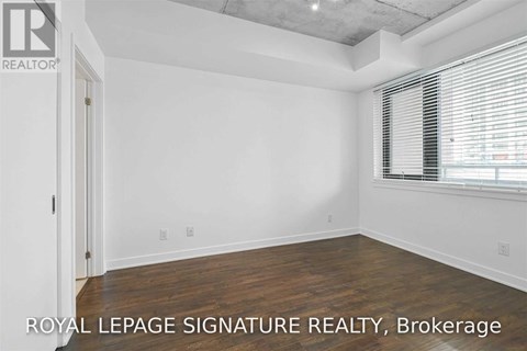 A white room with a door and a window with blinds.