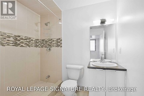 A bathroom with a toilet, sink, and shower.