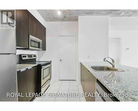 A kitchen with a refrigerator, microwave, oven and sink.