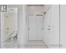 A white bathroom with a toilet, sink, and shower.