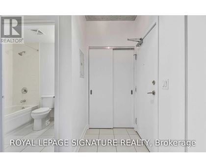 A white bathroom with a toilet, sink, and shower.