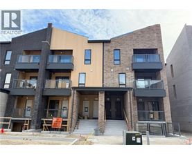A modern apartment building with balconies and a sign that says "NO PARKING" in front of it.