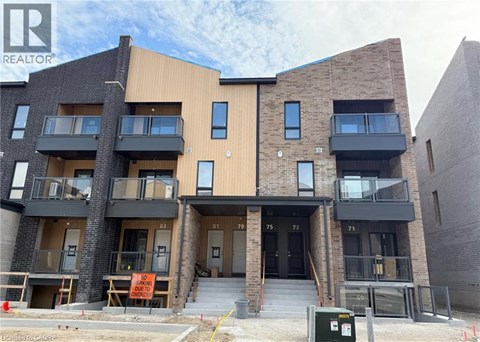 A modern apartment building with balconies and a sign that says "NO PARKING" in front of it.