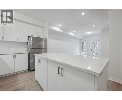 A white kitchen with a refrigerator and cabinets.