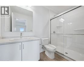 A white bathroom with a sink, toilet, and shower.