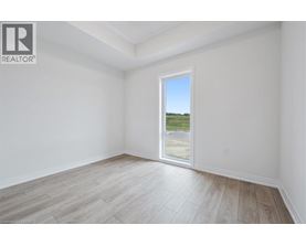 A room with a large window overlooking a field.